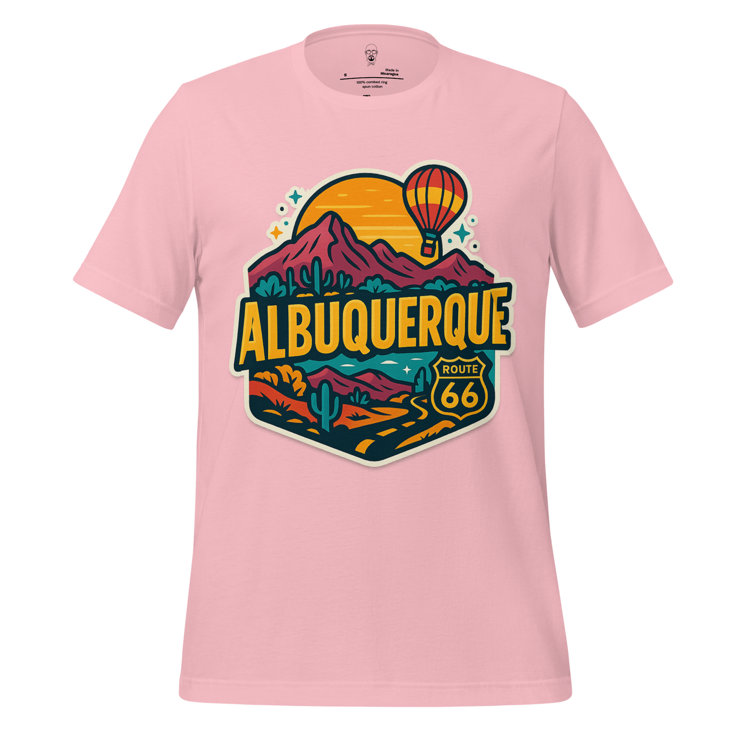 Pink t-shirt with colorful Albuquerque Route 66 graphic featuring mountains, hot air balloon, and desert landscape